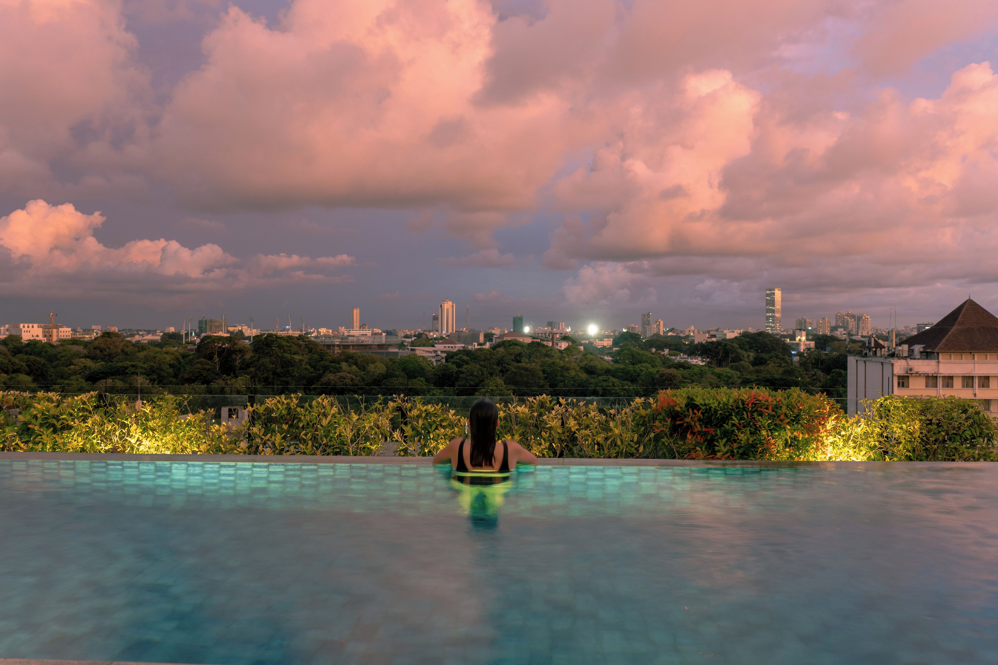 A person in a swimming pool with a cityscape in the background.