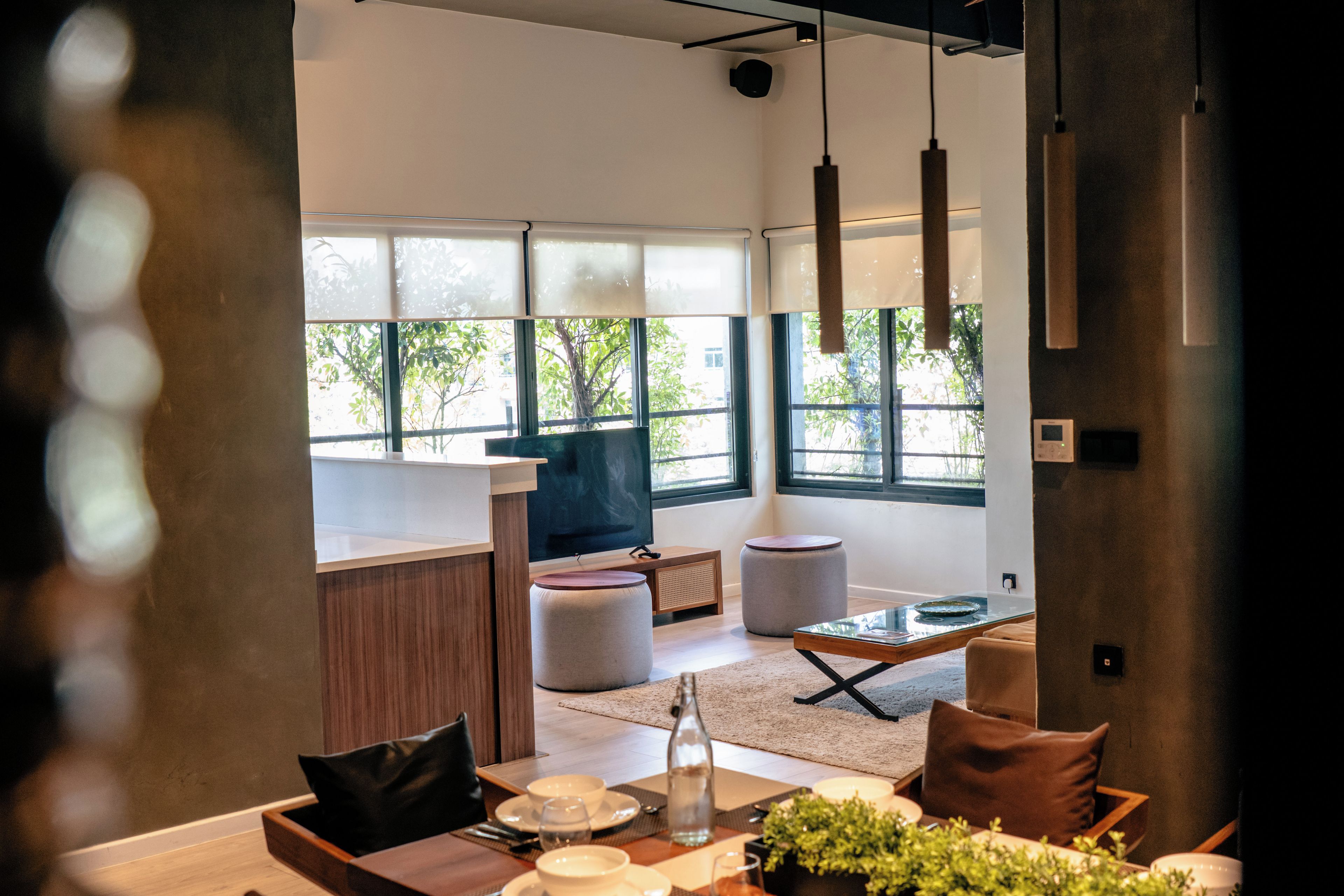Un interior moderno con comedor, cocina y ventanas amplias.