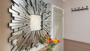 A modern wall with a geometric mirror and a vase of flowers. - Stunning 2-bed Apartment in Windsor - Free Parking (Windsor)
