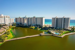 Resort com vários edifícios altos, um lago central e uma ponte que liga diferentes áreas.