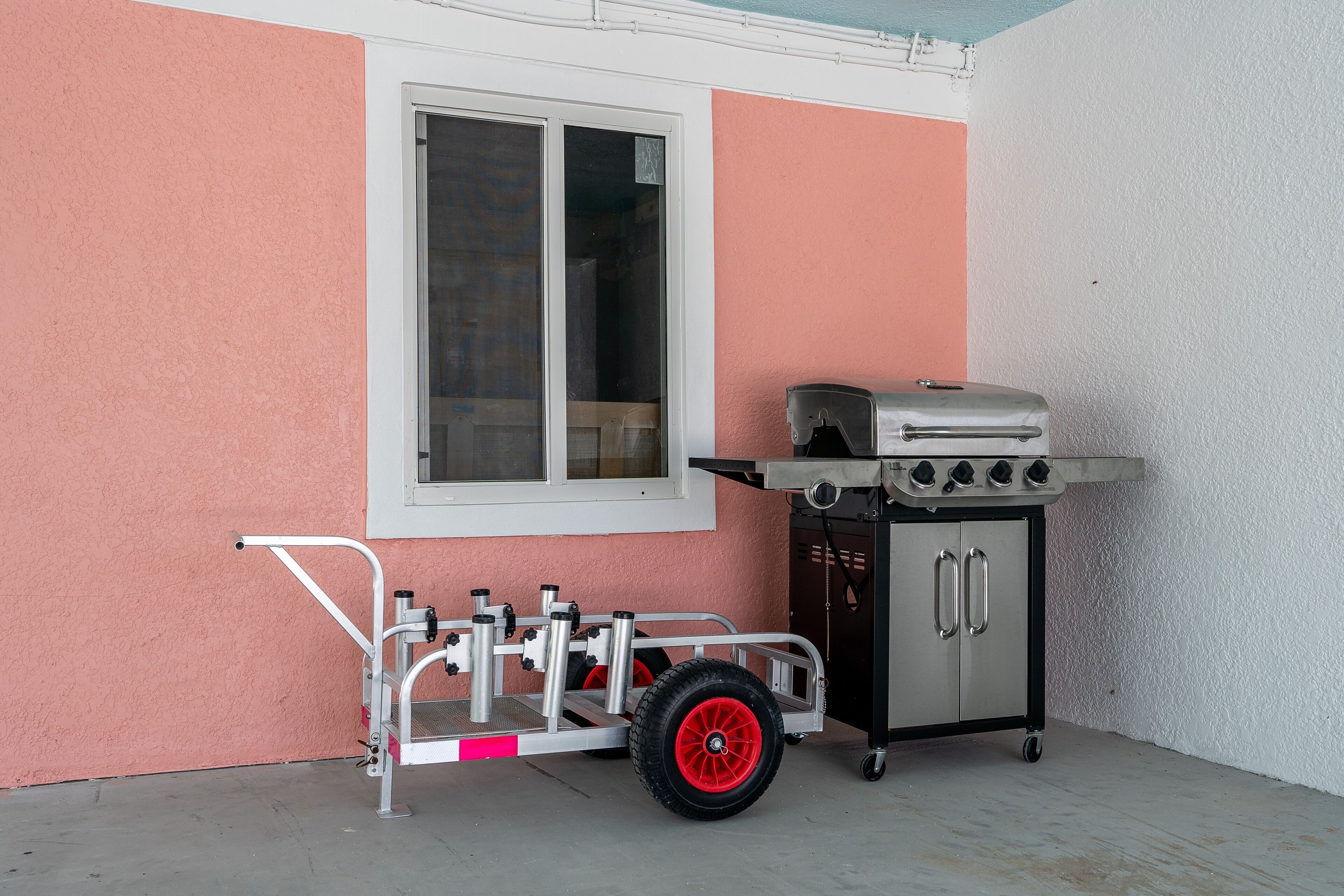 A portable grill cart with a window and a cabinet next to it.
