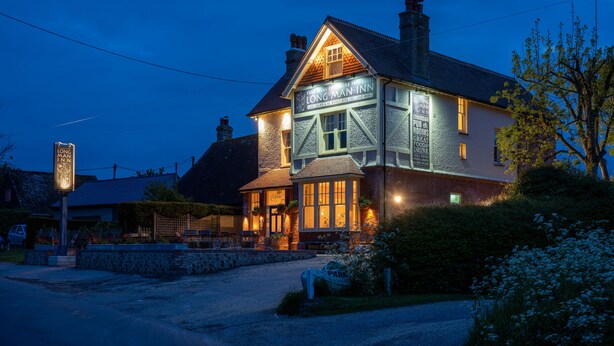 A traditional pub with a sign reading "The Long Man Inn" and a welcoming entrance. - Long Man Inn (Polegate)