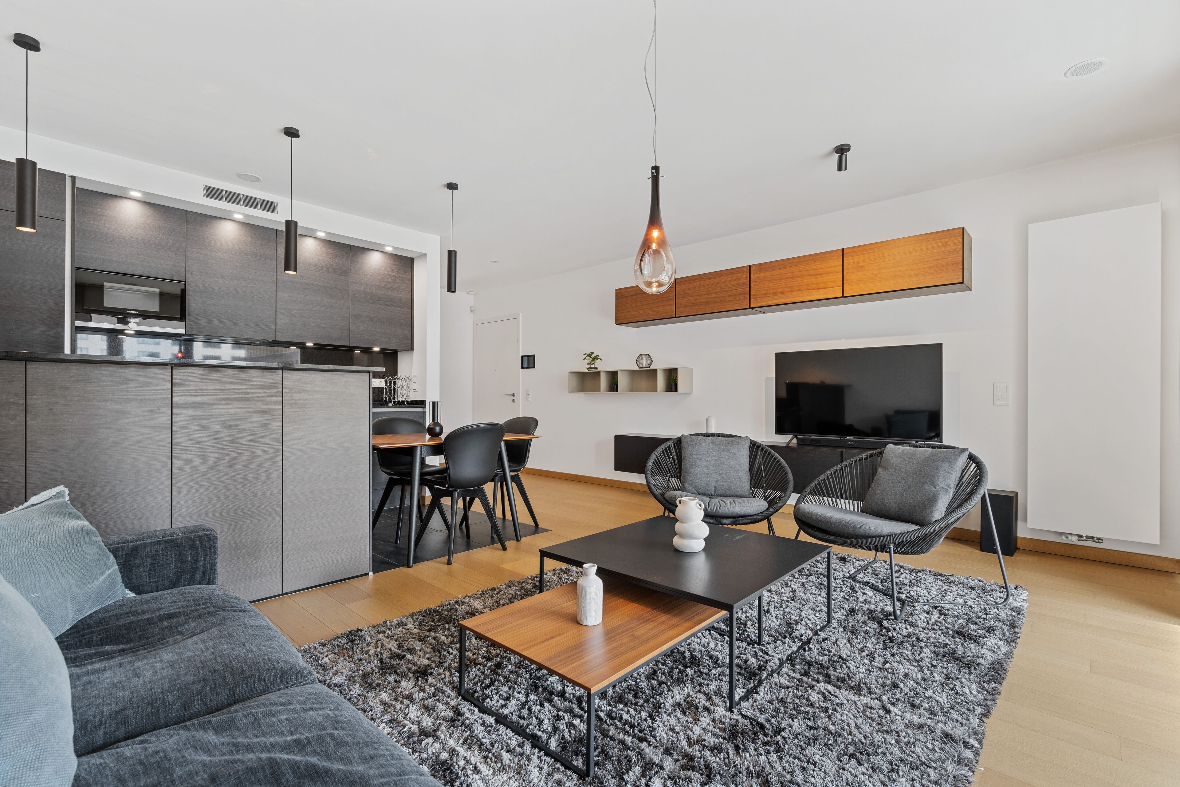 A modern living space with a kitchen, dining area, and seating area.