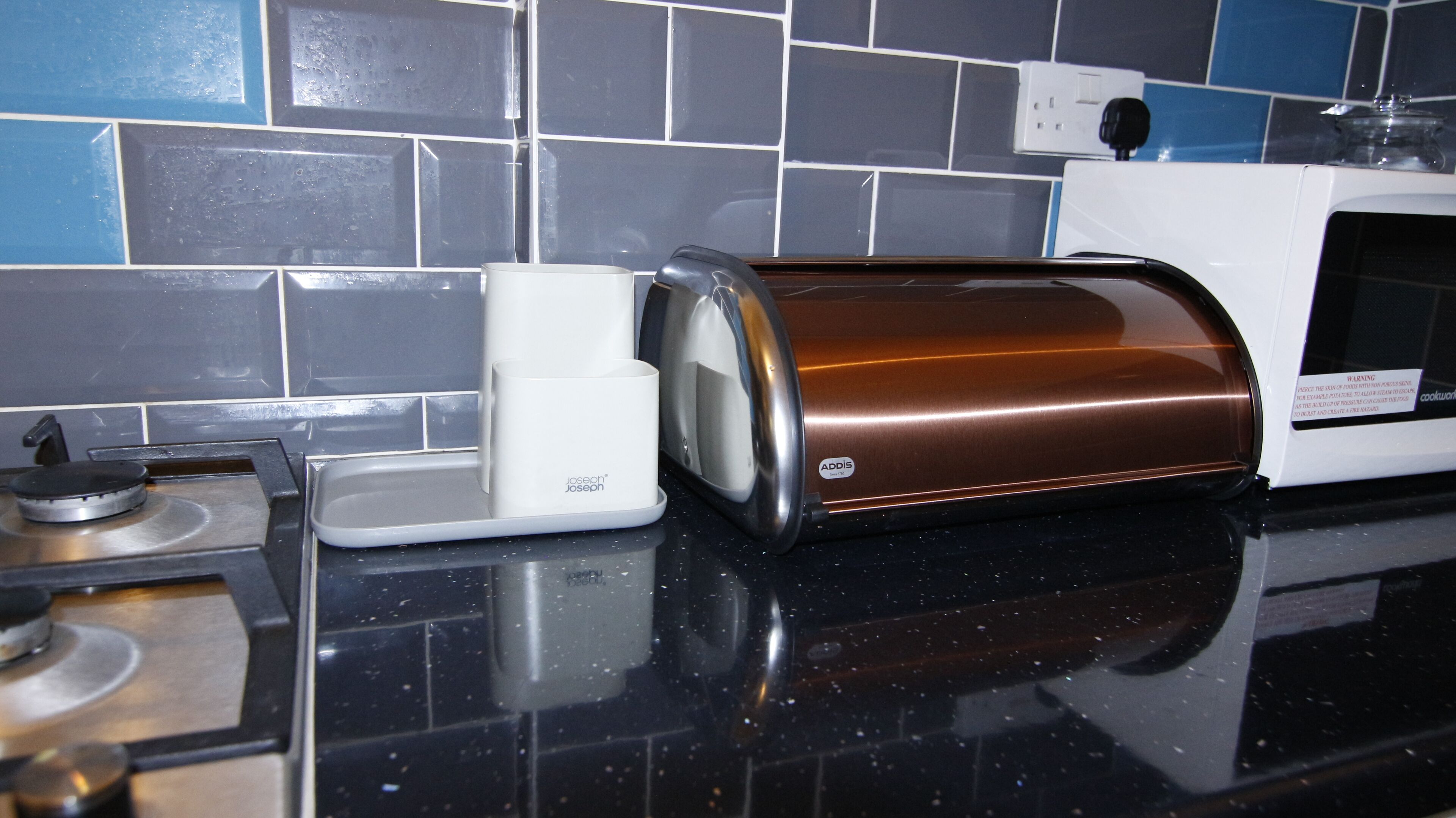 A kitchen counter with a toaster, a kettle, and a microwave.