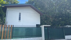 Un bâtiment d’un seul étage, doté d’une façade blanche, d’une petite fenêtre et d’un toit végétalisé.