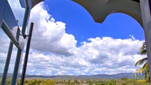 A view through an arched window with a clear sky and distant mountains. - Lola's DonJon + Peaceful prop. + Near Beaches + HTUB (San German)
