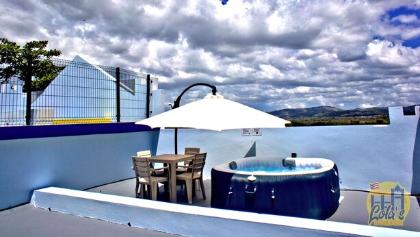 A rooftop patio with a table and chairs, a hot tub, and a view of the sky and mountains. - Lola's DonJon + Peaceful prop. + Near Beaches + HTUB (San German)
