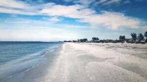 A beach with a clear sky and calm sea. -  BRING YOUR SAIL BOAT  (Punta Gorda)