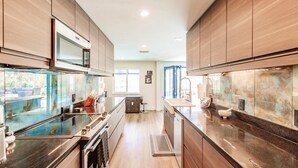 A modern kitchen with wooden cabinets, stainless steel appliances, and a large island. -  BRING YOUR SAIL BOAT  (Punta Gorda)