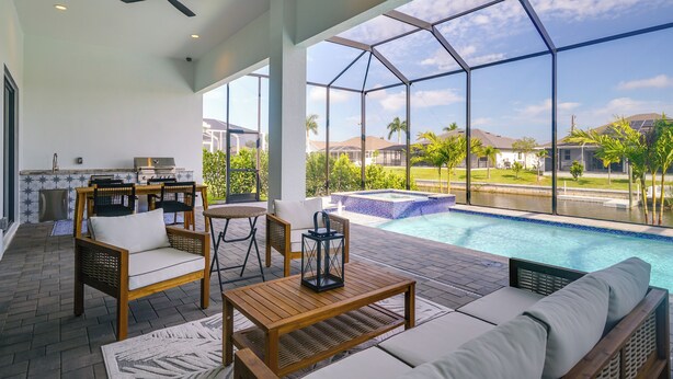 Un vaste espace extérieur doté d’une piscine, de coins salon et offrant une vue sur le paysage environnant.