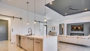 Une cuisine moderne dotée d’un îlot central, de meubles en bois et de luminaires suspendus.