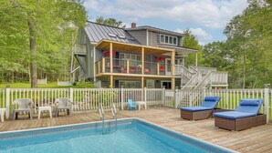 A pool area with a wooden deck, lounge chairs, and a white fence. - Searsport Paradise w/ Private Pool & Patio! (Searsport)
