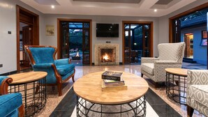 Un amplio salón con chimenea, asientos cómodos y un televisor grande.