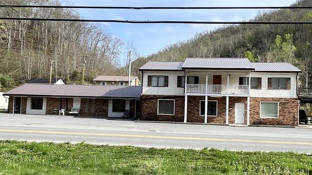 A two-story motel with a flat roof, a balcony on the second floor, and a front parking area. - Hatfield’s Lodging LLC, in the heart of Hatfield McCoy trail system. (Matewan)