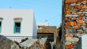A stone staircase leading up to a building with a white facade and green windows. - Amorgos Elegant Houses, Villa 2 (Amorgos)
