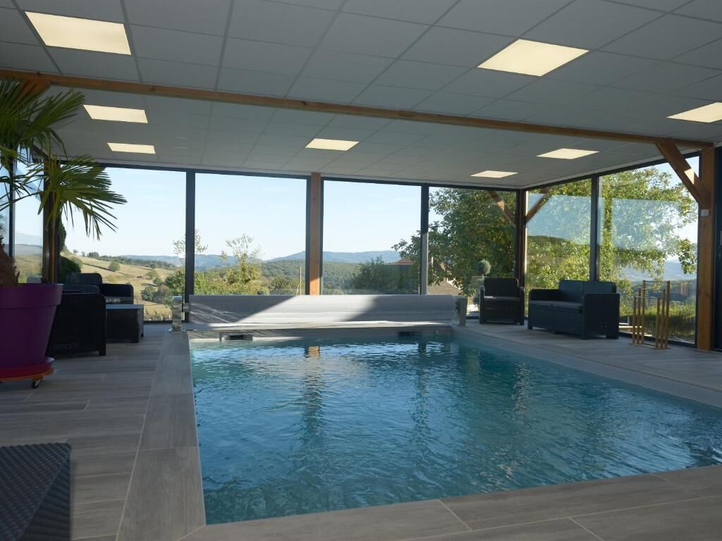 Een binnenzwembad, parasols bij het zwembad en ligstoelen