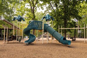 A playground with slides and climbing structures. - Lakeside Resort Cabin Steps to Table Rock Lake - Minutes to SDC! (Branson)