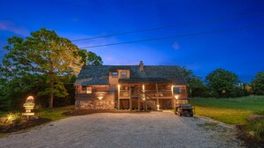 A rustic log cabin with a stone foundation, a wooden porch, and a covered front entrance. - Lakeside Resort Cabin Steps to Table Rock Lake - Minutes to SDC! (Branson)