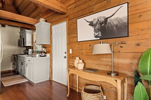 A wooden interior with a kitchen, a dining area, and a living space. - Lakeside Resort Cabin Steps to Table Rock Lake - Minutes to SDC! (Branson)