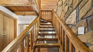A wooden staircase with a stone wall on one side and a wooden door on the other. - Lakeside Resort Cabin Steps to Table Rock Lake - Minutes to SDC! (Branson)