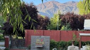 A pool area with a sign reading "YO Tierra de Sol," surrounded by a red wall, with mountains in the background.
