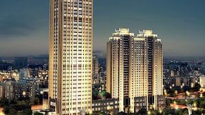 Two high-rise buildings with a dense urban skyline in the background.