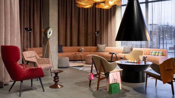 A modern living room with a sofa, chairs, a coffee table, and a fireplace. - Moxy Outletcity Metzingen (Metzingen)