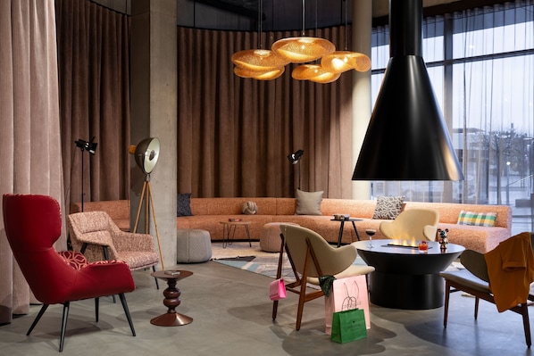 A modern living room with a sofa, chairs, a coffee table, and a fireplace.