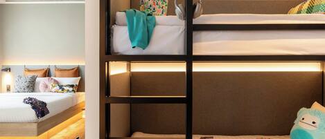 A bunk bed with headphones, a blanket, and toys on the top bunk.