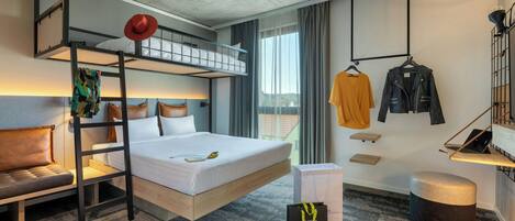 A modern hotel room with a bunk bed, a desk, a chair, a wardrobe, and a view of the outdoors.