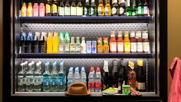 A beverage refrigerator stocked with various drinks, including sodas, juices, and alcoholic beverages.