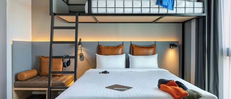 A bunk bed room with a desk, a chair, and a laptop.