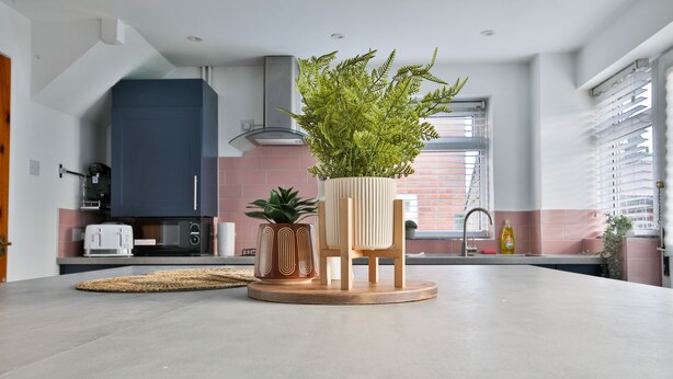 A modern kitchen with a central island, a built-in microwave, and a coffee machine. - Spacious 3 Bedroom House in Barry (Barry)