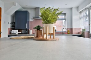 A modern kitchen with a central island, a built-in microwave, and a coffee machine. - Spacious 3 Bedroom House in Barry (Barry)