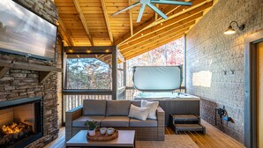 Un interior acogedor con chimenea de piedra, un sofá cómodo y un ventanal con vistas panorámicas.