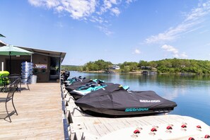 A dock with watercraft and a building with outdoor seating.