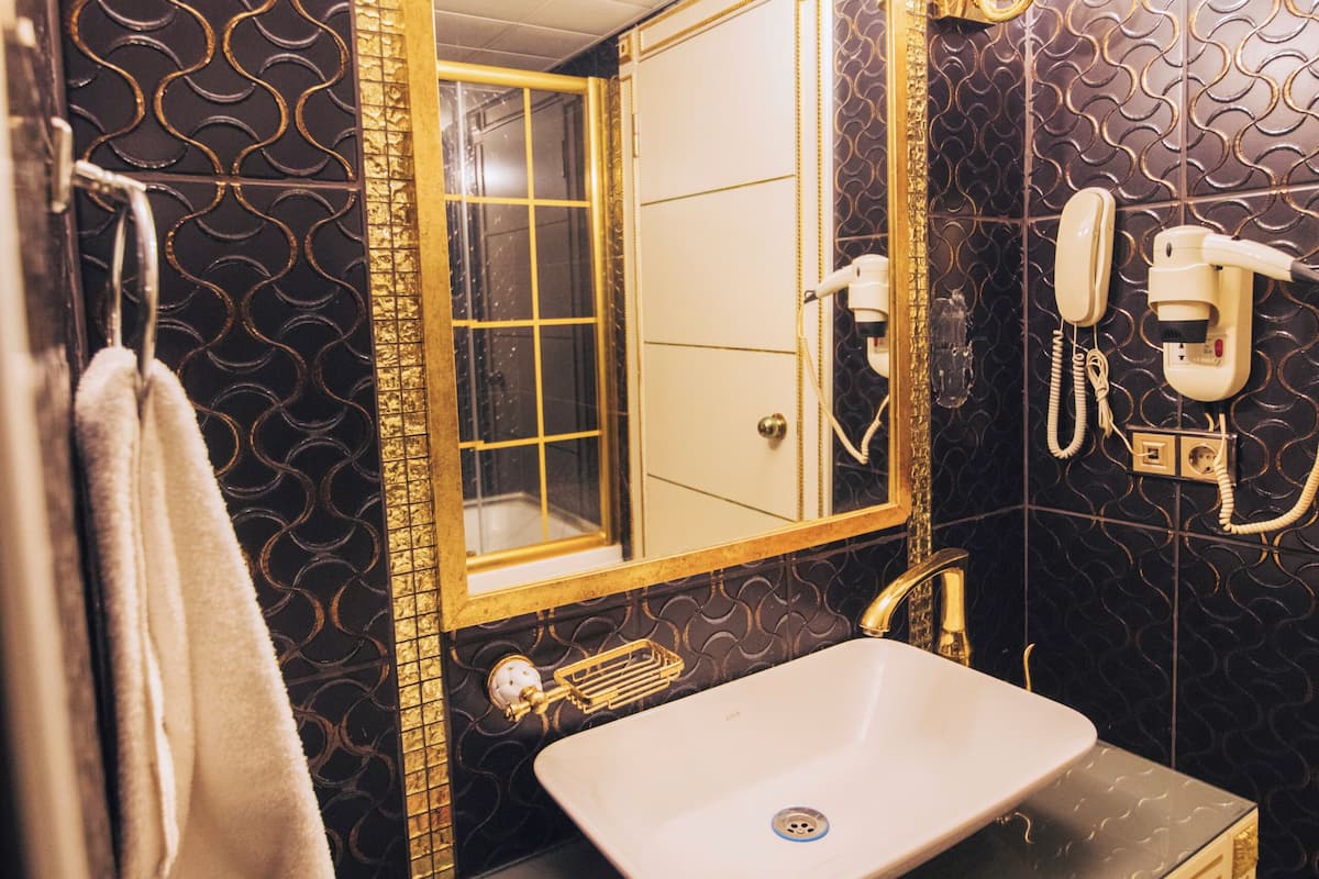 A bathroom with a large mirror, a sink, and a telephone.
