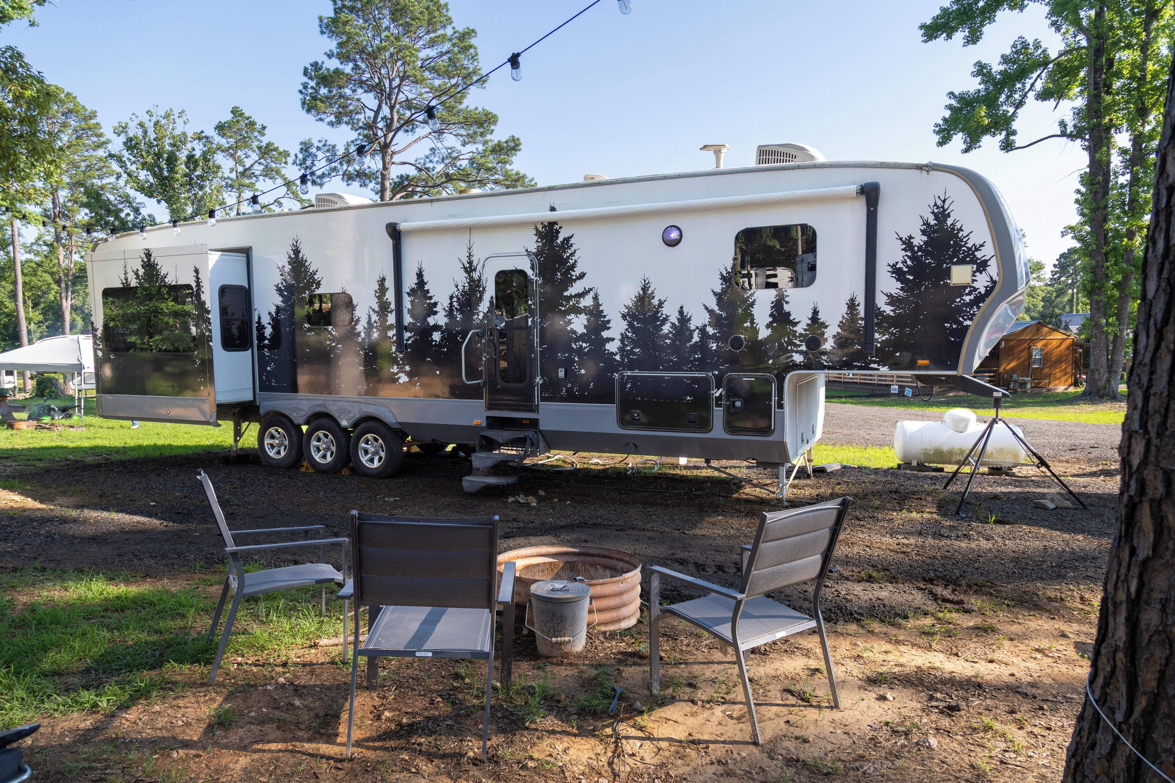 A recreational vehicle with a flatbed, a covered area, and a small table with chairs.