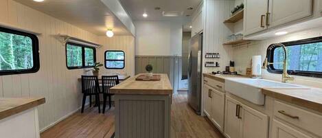 A modern kitchen with a central island, wooden flooring, and built-in cabinetry.
