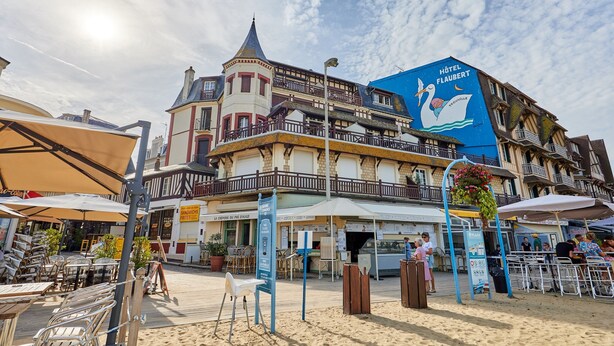 Un hôtel de style architectural européen traditionnel, doté d’une tour imposante et d’un balcon.