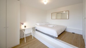 Una habitació amb un llit, escriptori i una cadira.