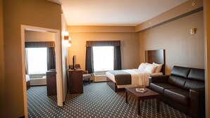 Una habitación de hotel con cama, sofá, escritorio y una silla.