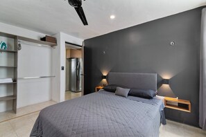 A modern bedroom with a large bed, bedside tables, a wardrobe, and a built-in shelf. - ELEGANT HOUSE / NEAR THE AIRPORT, MERIDA, YUCATAN. HOUSE MR (Mérida)