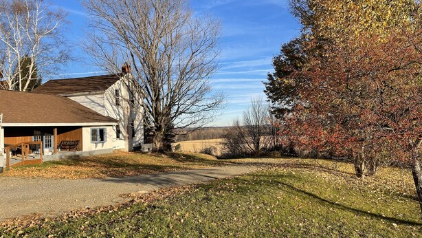 A two-story house with a visible garage and a front porch. - Quiet farmhouse with amazing views - close to skiing in Ellicotville! (Little Valley)