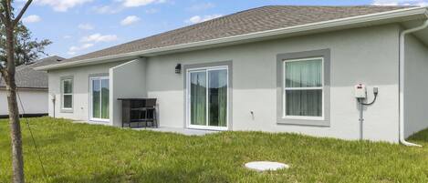 A single-story house with a flat roof, large windows, and a small porch area.