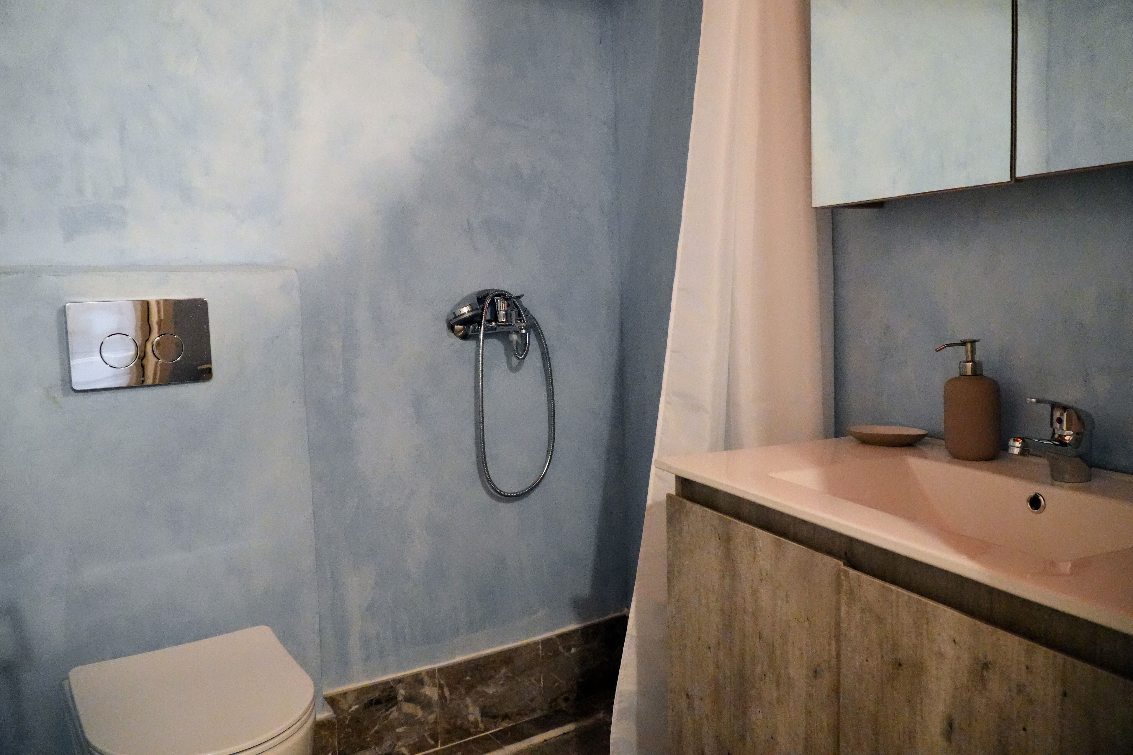Une salle de bain avec une douche, des toilettes et un lavabo.