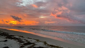 Una spiaggia con onde e un tramonto.