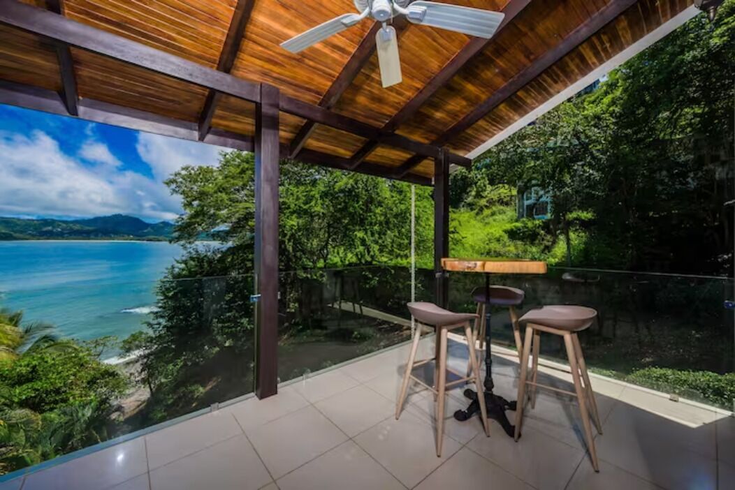 Un espacio de estar al aire libre cubierto con vistas a un paisaje costero.