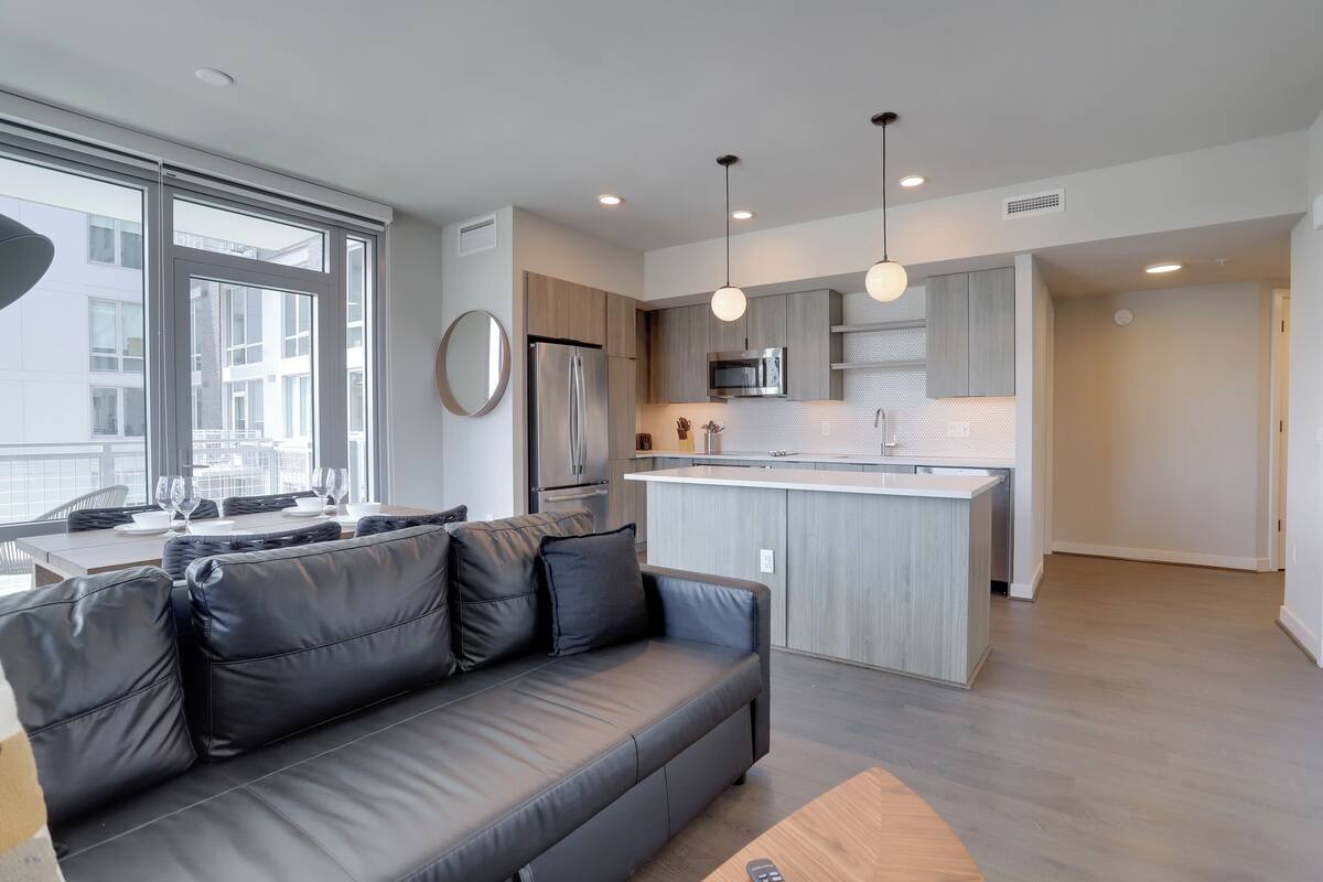 A modern kitchen with a central island, stainless steel appliances, and pendant lighting.