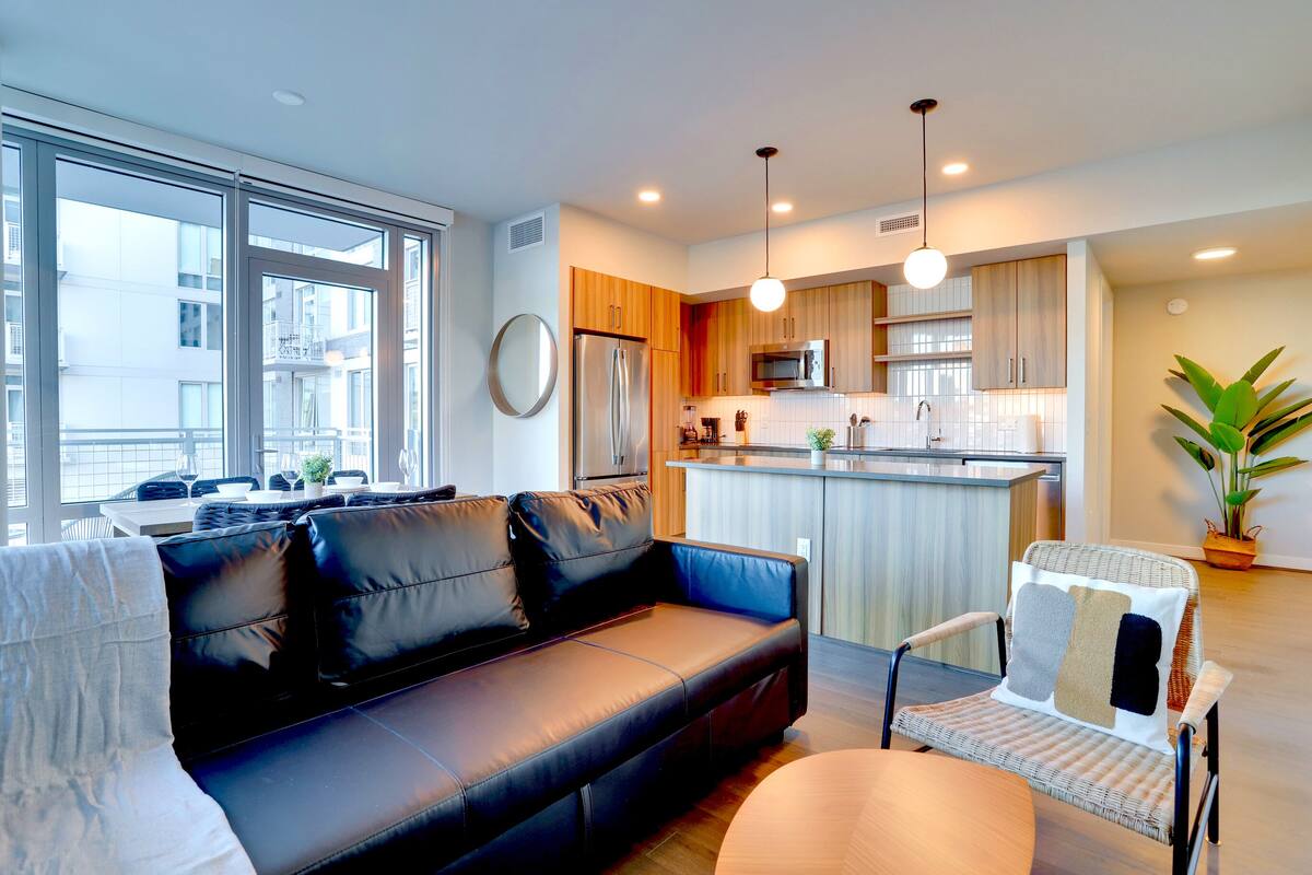 A modern apartment with a living room, kitchen, and dining area.